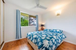 Schlafzimmer mit einem Bett und einem Fenster in der Unterkunft Compton House in Iluka