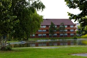 ein Gebäude mit einem Teich vor einem Gebäude in der Unterkunft Campanile Lille - Lomme in Lomme