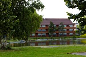 un bâtiment avec un étang en face d'un bâtiment dans l'établissement Campanile Lille - Lomme, à Lomme