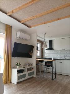 een keuken met een tafel en een tv aan de muur bij Cambrils Bahía in Cambrils +12 foto's