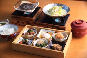 una lonchera de madera con varios platos de comida en una mesa en Yufudake Ichibo no Yado Kirara en Yufuin