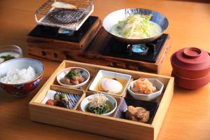 a wooden lunch box with various dishes of food on a table at Yufudake Ichibo no Yado Kirara in Yufu