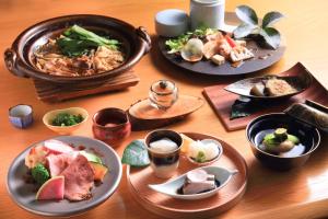 a wooden table with plates of food on it at Yufudake Ichibo no Yado Kirara in Yufu