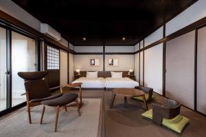 sypialnia z łóżkiem, stołem i krzesłami w obiekcie Yufudake Ichibo no Yado Kirara w mieście Yufu