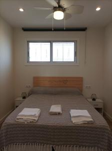 een slaapkamer met een bed met twee handdoeken erop bij Cambrils Bahía in Cambrils