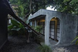 a house with a staircase leading up to a building at Dormitory at Semadi living in Sukawati