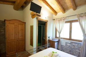 a room with a table and a television on the wall at Agriturismo BioBiò in Vobarno