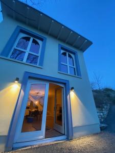 a blue house with sliding glass doors at night at Weinbergshaus mit Blick auf's Wasser in Salzatal
