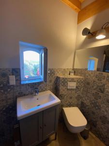 a bathroom with a sink and a toilet and a window at Weinbergshaus mit Blick auf's Wasser in Salzatal