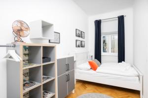 małą sypialnię z łóżkiem i półkami w obiekcie Luxury Suites Liechtenstein w Wiedniu