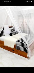 a bed with black and white pillows and a net at The Dream Resort in Ella