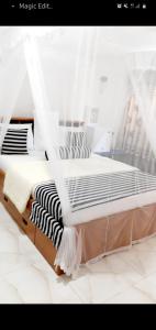 埃拉的住宿－The Dream Resort，卧室配有一张带白色窗帘的大床