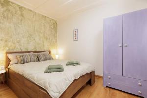 sypialnia z dużym łóżkiem i fioletową szafką w obiekcie Liston Sweet House w Korfu