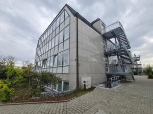 un gran edificio de cristal con una escalera lateral. en check-inn hotels - Offenbach, en Offenbach