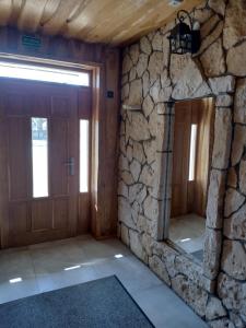 Pokój z kamienną ścianą i drewnianymi drzwiami w obiekcie Jurajska Chata w mieście Bobolice