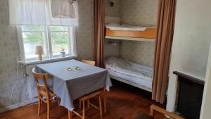 a dining room with a table and a bunk bed at Rolfskärrs Stugby in Nygård +82 photos
