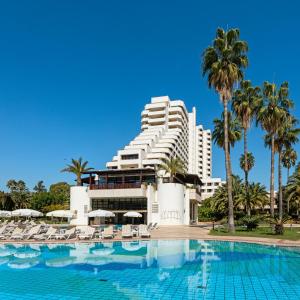 a hotel with a swimming pool in front of a building at Özkaymak Falez Hotel in Antalya