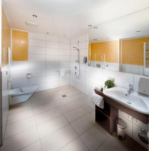 a bathroom with a tub and a sink and a shower at GuestHouse Mannheim in Mannheim