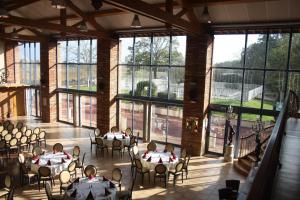 a room with tables and chairs and large windows at Les Ecuries de la Tour in Mondonville