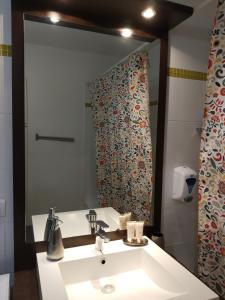La salle de bains est pourvue d'un lavabo et d'un grand miroir. dans l'établissement Cosy Stay, à Saint-Germain-en-Laye