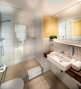 a white bathroom with a sink and a mirror at GuestHouse Mannheim in Mannheim