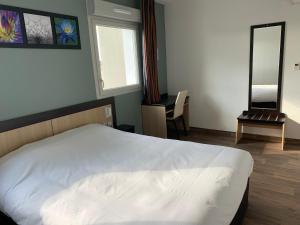 - une chambre avec un lit blanc et un miroir dans l'établissement B&B HOTEL Romilly-sur-Seine, à Romilly-sur-Seine