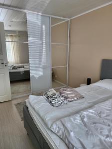 1 dormitorio con cama blanca y espejo en Rivitalo-asunto Kausalassa, en Iitti