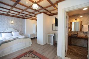 a bedroom with a bed and a television in it at Celsus Boutique Hotel in Selçuk