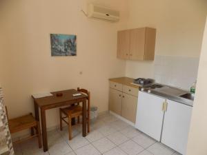 a small kitchen with a table and a sink at JERRY'S STUDIOS LASSI in Lassi