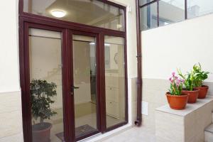uma porta de vidro deslizante num edifício com vasos de plantas em Studio'24 em Constança