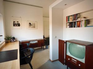 sala de estar con TV y escritorio con sillas en Weinloft "1" Design trifft Wein! Urlaub auf dem Weingut mit Ladestation E10, en Köwerich 6 fotos más