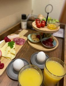 une table avec des assiettes de nourriture et deux verres de jus d'orange dans l'établissement B&B Joy's, à Berbourg