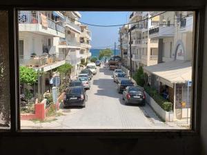 a view from a window of a street with parked cars at Perea white suites in Perea +1 photo