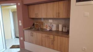 a kitchen with wooden cabinets and a sink at Perea white suites in Perea