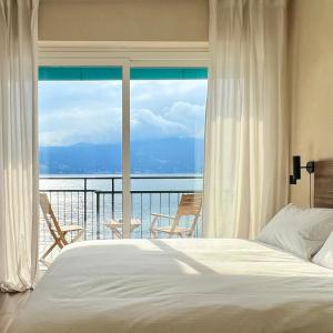 ラヴェーノ・モンベッロにあるLa Dama del Portoのベッドルーム1室(ベッド1台付)、景色を望むバルコニーが備わります。