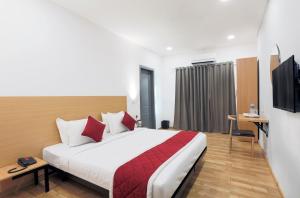 バンガロールにあるAlchemy Suitesのベッドとテレビが備わるホテルルームです。
