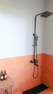 eine Dusche im Bad mit orangefarbenen Fliesen in der Unterkunft Kultur Pecatu Micro Villa in Uluwatu