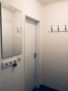 baño con espejo y puerta en Gemütliche Ferienwohnung in Altreichenau en Altreichenau