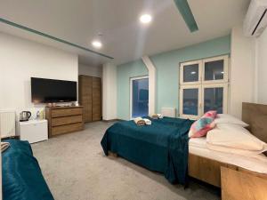 a bedroom with two beds and a flat screen tv at Hotel Story in Sarajevo