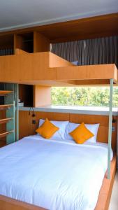 ein Schlafzimmer mit einem Etagenbett mit weißer Bettwäsche und orangefarbenen Kissen in der Unterkunft Kultur Pecatu Micro Villa in Uluwatu