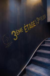 eine Treppe mit einem Schild an der Wand in der Unterkunft Grand Place Hôtel "Boutique et Appart'hôtel" in Arras