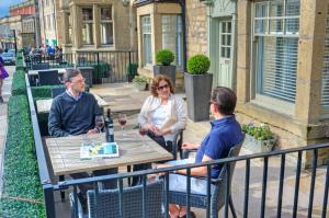 a group of people sitting at a table on a patio at The Bondgate Boutique in Alnwick