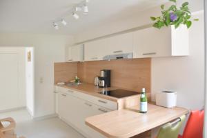 cocina con armarios blancos y encimera de madera en Ferienwohnung Gohrisch, en Kurort Gohrisch