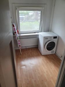 uma lavandaria com uma máquina de lavar roupa e uma janela em Single family home in Hillegersberg - Schiebroek em Roterdã