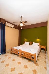 een slaapkamer met een groot bed in een groene muur bij Southgate Apartments in Agios Georgios