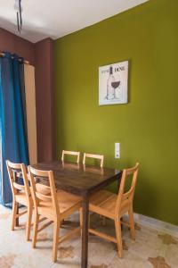 jadalnia z drewnianym stołem i krzesłami w obiekcie Southgate Apartments w mieście Agios Georgios