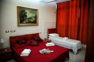 ローマにあるB&B Emilioのベッドルーム1室(赤いシーツを使用したベッド2台付)