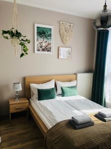a bedroom with a bed with green and white pillows at Apartament słoneczny in Olsztyn