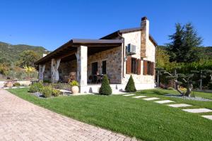 a stone house with a lawn in front of it at Pinelia Home in Mirtófiton