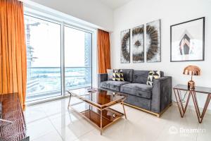 a living room with a couch and a large window at Dream Inn Apartments- West Wharf Tower Canal View in Dubai